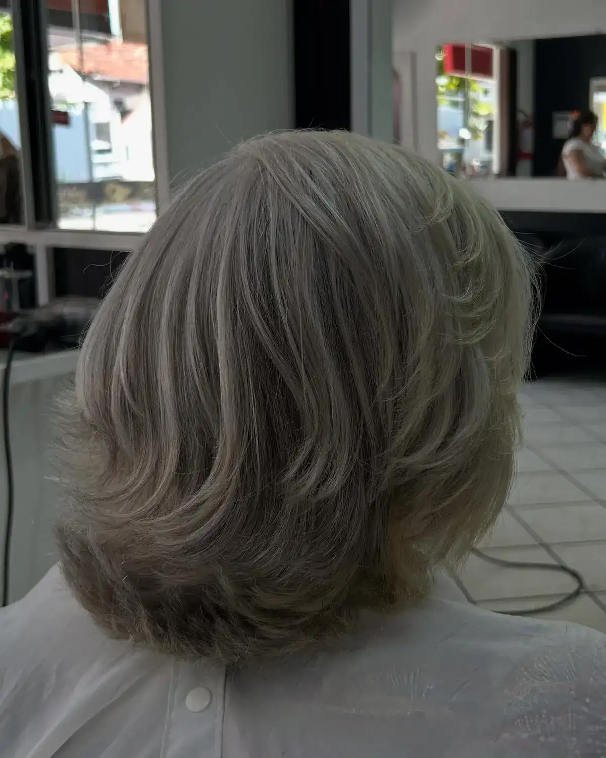 Corte em camadas suaves em cabelo branco natural, de costas