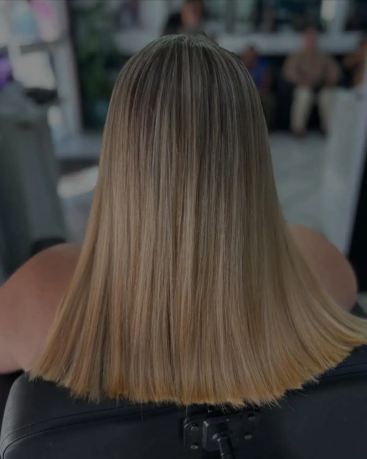 Loiro com mechas iluminadas e corte reto, de costas